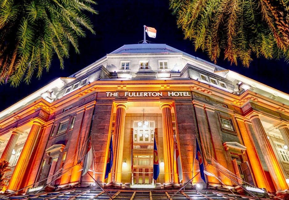 Stunning night view of the iconic Fullerton Hotel in Singapore, beautifully illuminated against a dark sky.