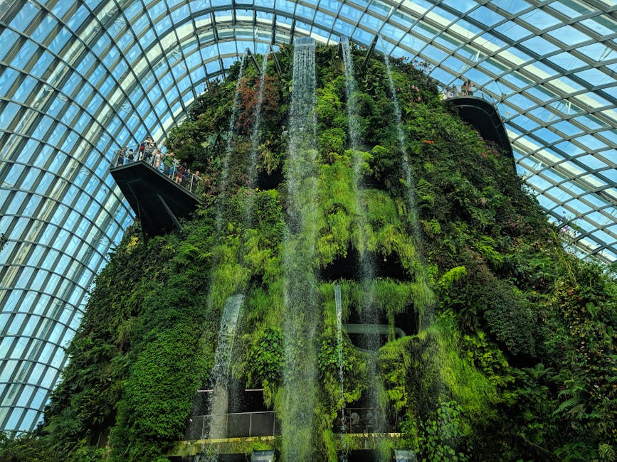 Lush indoor waterfall at Singapore's Gardens by the Bay's Cloud Forest, a premier tourist attraction.